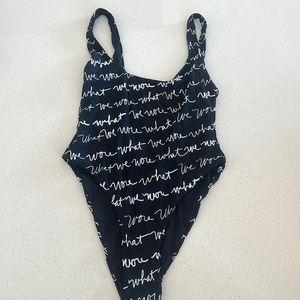 We Wore What black logo one-piece bathing suit.